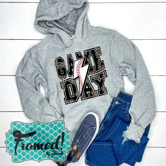 heather gray hoodie with leopard print words "Game Day" and a baseball print lighting bolt over the top - styled with jeans a blue sneakers