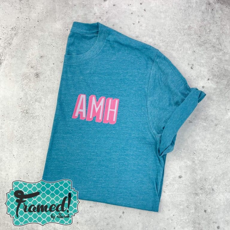 blue tshirt folded with pink block letter monogram