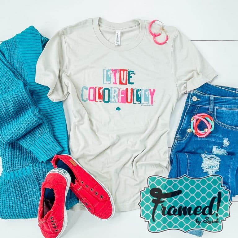 Gray tee shirt with colorful "live colorfully" lettering styled with red shoes, turquoise sweater, and jeans