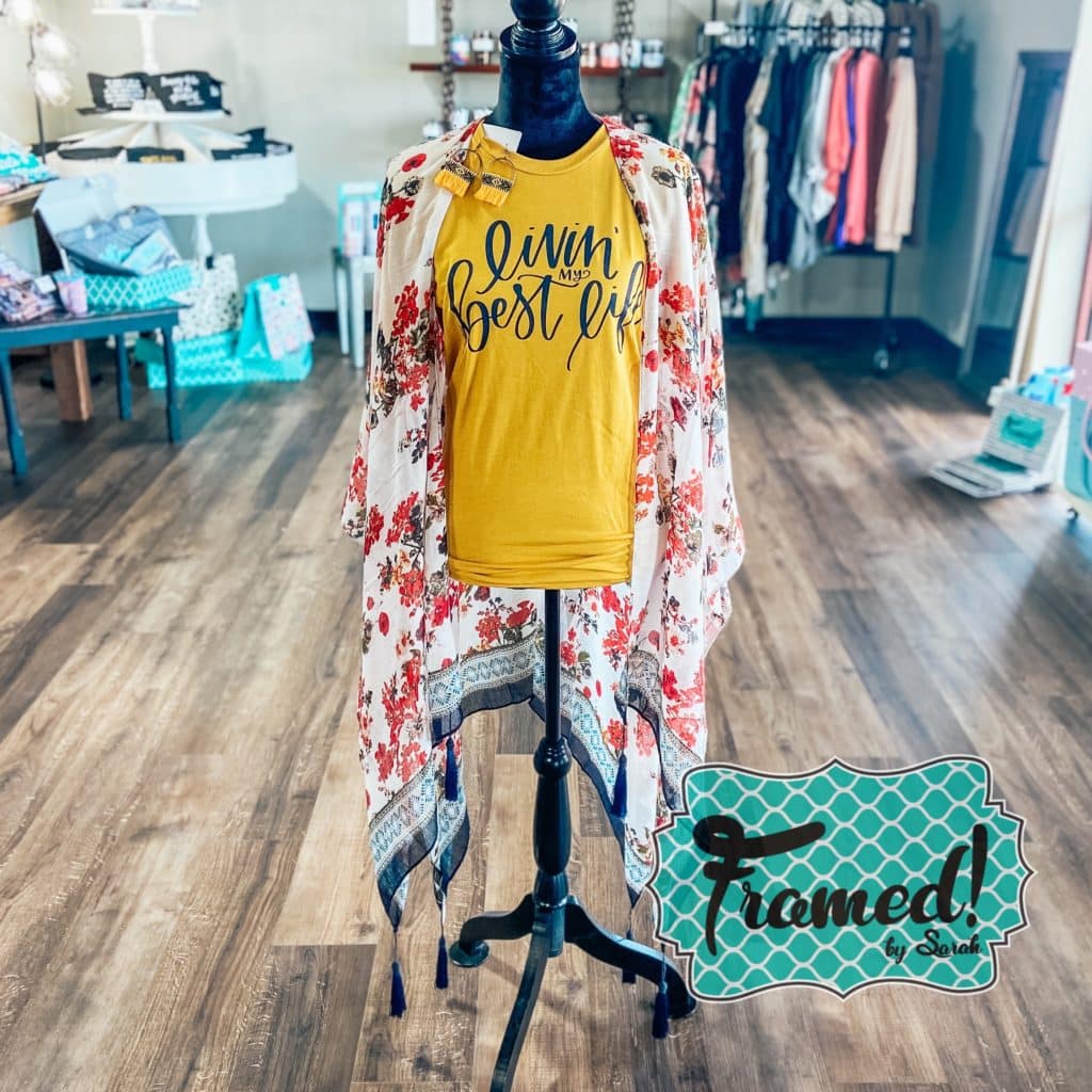 pink and navy floral print kimono styled over a yellow "livin my best life" tee on a mannequin in a store