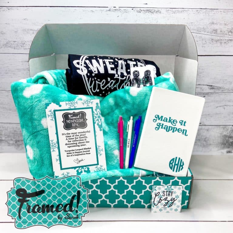 Monogram Subscription Box open with a teal blanket, Black tshirt, pens and notebook