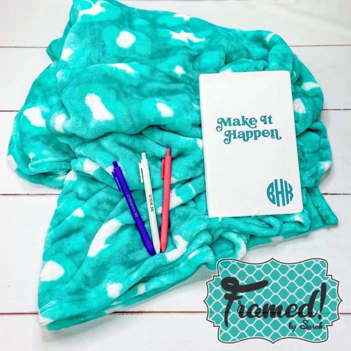 turquoise blanket with notebook and pens on the wood floor