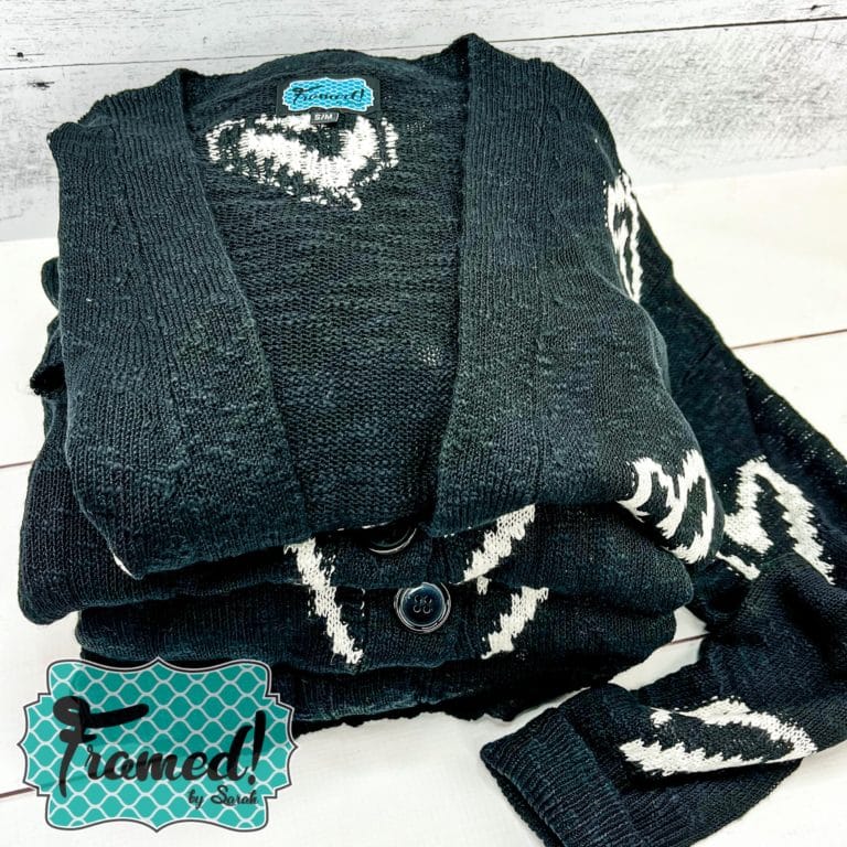 black cardigan with white hearts folded on a table