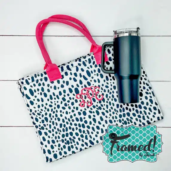 black spotted tote with hot pink handle and Monogram displayed with black tumbler