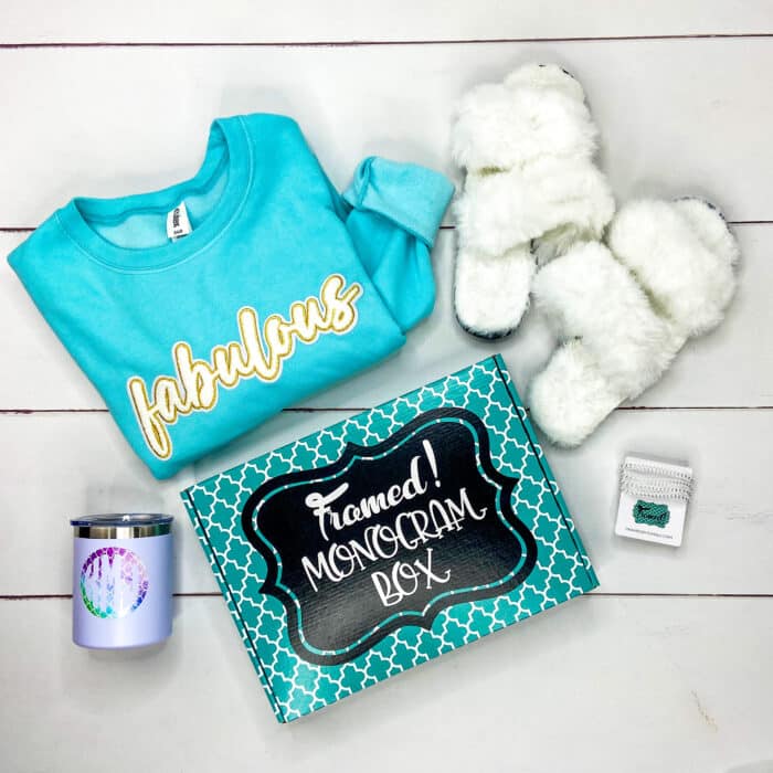 blue "fabulous" sweatshirt, white fluffy slippers, "wildflowers" tshirt, teal beaded bracelets, monogrammed tumbler and a Monogram Box on a white plank floor