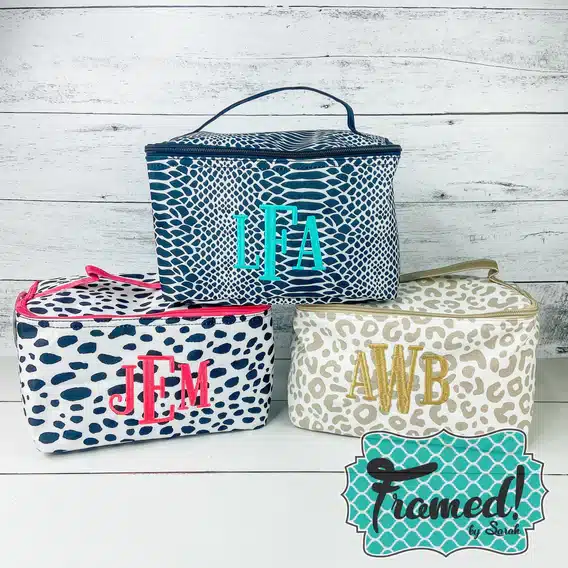 3 colorfully patterned and monogrammed travel bags stacked.