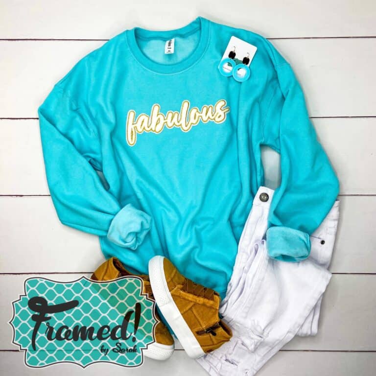 Blue sweatshirt with the word "fabulous" across the chest + white jeans + Teal earrings + camel sneakers. Framed by Sarah