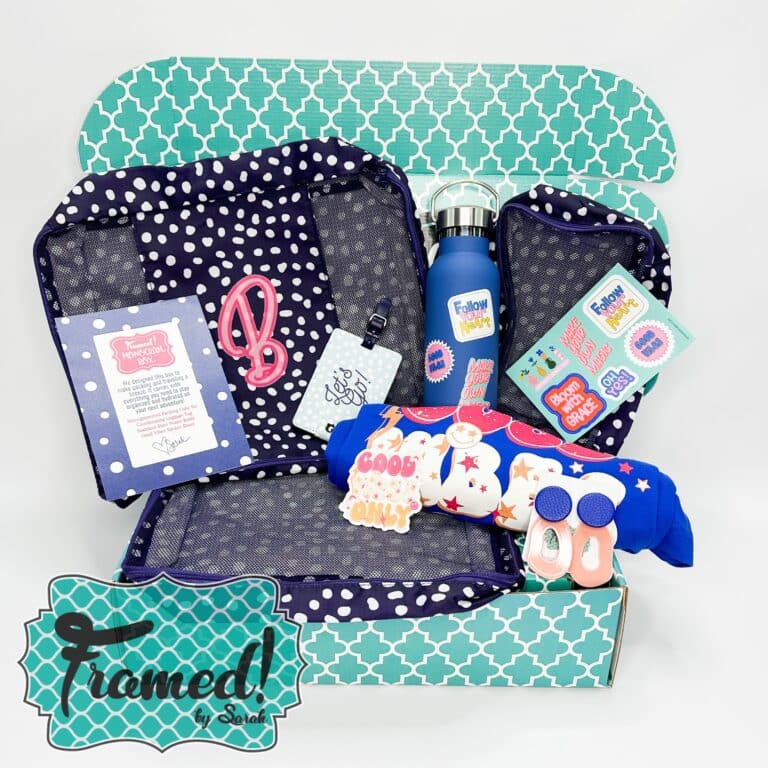 Subscription box full of travel bags, tshirt, water bottle, stickers, travel tags, and earrings.