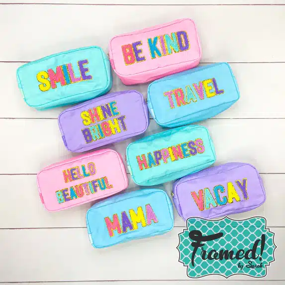 6 Sparkle Chenille Accessory Bags: teal bag with multicolor SMILE patch, pink bag with multicolor BE KIND patch, purple bag with multicolor SHINE BRIGHT patch, blue bag with multicolor TRAVEL patch, pink bag with multicolor HELLO BEAUTIFUL patch, teal bag with multicolor HAPPINESS patch, blue back with multicolor MAMA patch, and purple bag with multi color VACAY patch