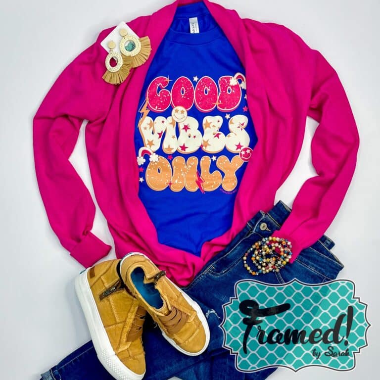 cobalt blue tshirt with pink, white and gold retro words "Good Vibes Only" styled with jeans, hot pink cardigan, and gold accessories