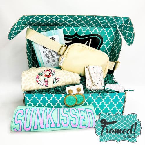 Framed by Sarah May Monogram Box open and displaying its full contents - ivory leopard monogrammed t-shirt, mint sunkissed tshirt, ivory belt bag, turquoise jute disk earrings, ivory keychain wallet