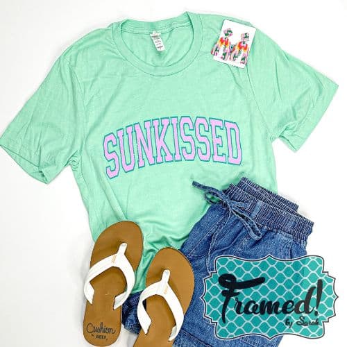 Mint Sunkissed t-shirt styled with white flip-flops, denim shorts and colorful beaded earrings