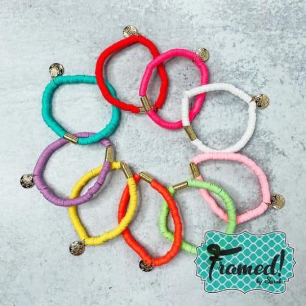 9 colorful bracelets laid in a overlapping circle.