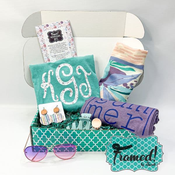teal box full of summer contents to include a purple Summer tee, turquoise monogramed tank top, a colorful printed kimono, earrings, hair clip, and sunglasses. June 2023 Monogram Box - Framed by Sarah Subscription Box for women