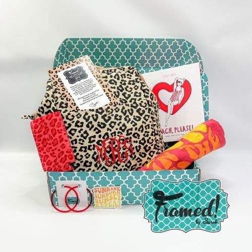 July 2023 Ultimate Monogram Box open with contents displayed. Content include: Leopard backpack with red monogram, red "Fun in the Sun" t-shirt, red hoop earrings, red can coozie, read heart floaty in its packaging.