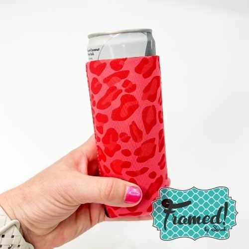 hand holding a drink inside a red leopard can Koozie