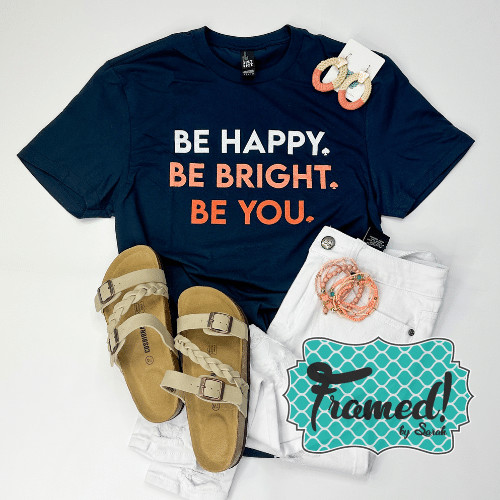 be happy. be bright. be you. navy tee shirt styled with white jeans, tan sandals, and coral accessories