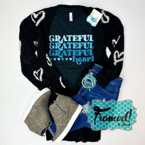 Black tshirts with the words "Grateful Grateful Grateful Heart" styled with black cardigan with white hearts, gray wedge sneakers, and turquoise accessories