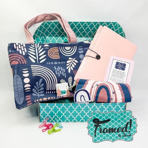 December 2023 Monogram Box contents in the teal box. Contents include: Navy and blush tote bag, blush, file folder, personalized zipper pouch, colorful clips, pink and navy rainbow tshirt, earrings