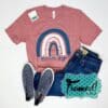 Mauve tshirt with pink and navy rainbow styled with dark denim, navy sneakers, and pink earrings