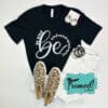 black "be kind" tshirt styled with distressed white jeans, leopard print sneakers, black and white accessories