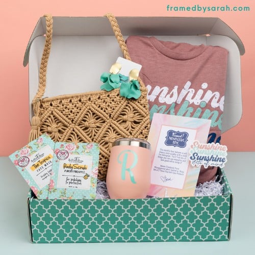 July 2025 Monogram Box contents include: Sunshine State Of Mind mauve tee, turquoise earrings, peach cup with turquoise monogram, selfcare products, and custom macrame crossbody bag