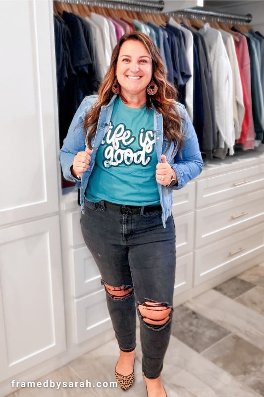 Sarah Williams wearing the blue Life Is Good tee styled with distressed black jeans, leopard ballet flats, leopard earrings, and denim jacket