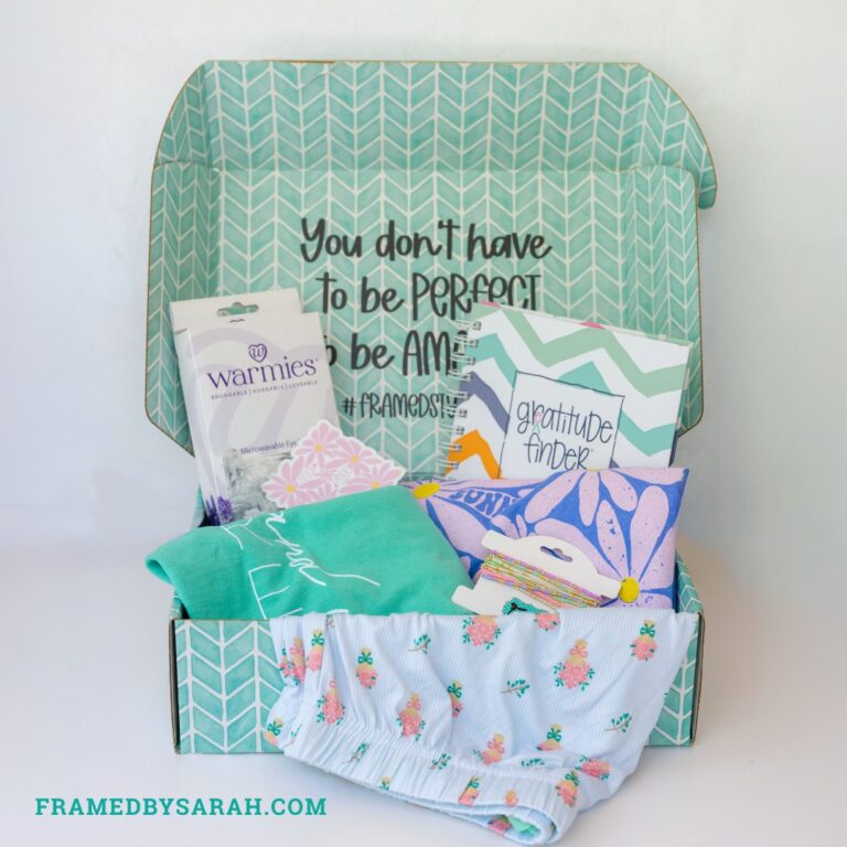 floral pajama shorts, teal t-shirt, blue t-shirt, eye mask, bracelet stack, and journal displayed in a teal subscription box