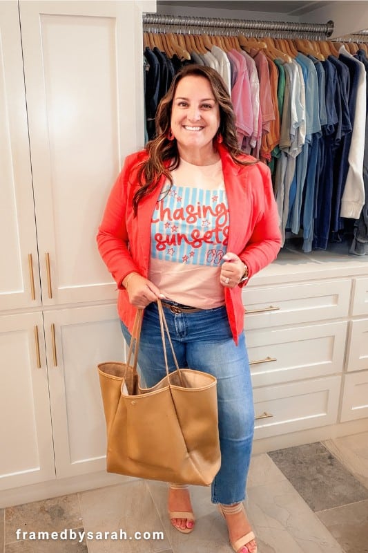 Sarah wearing the "chasing sunsets" tshirt styled with coral blazer, jeans, large tote and heals