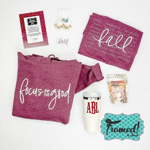 August 2023 Ultimate Monogram Box contents laid out on a white surface. Content include: "Focus on the Good" Maroon Hoodie, All things Fall Maroon tshirt, ivory mug with ABL monogram, taffy, ivory earrings, and fall sticker